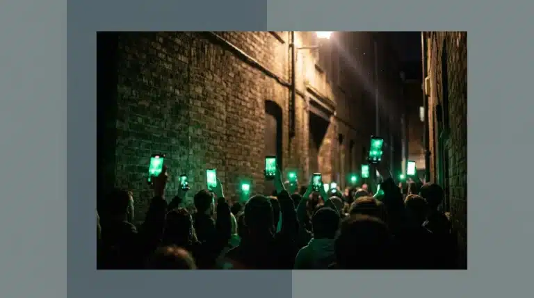A low-angle professional photograph of a silhouetted crowd in a darkened urban alley, holding up smartphones emitting glowing green light, symbolizing digital activism and global discourse.