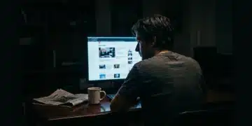 A person viewing a fragmented news feed on a computer screen, illuminated by dramatic chiaroscuro lighting, emphasizing the isolation of algorithmic information consumption.